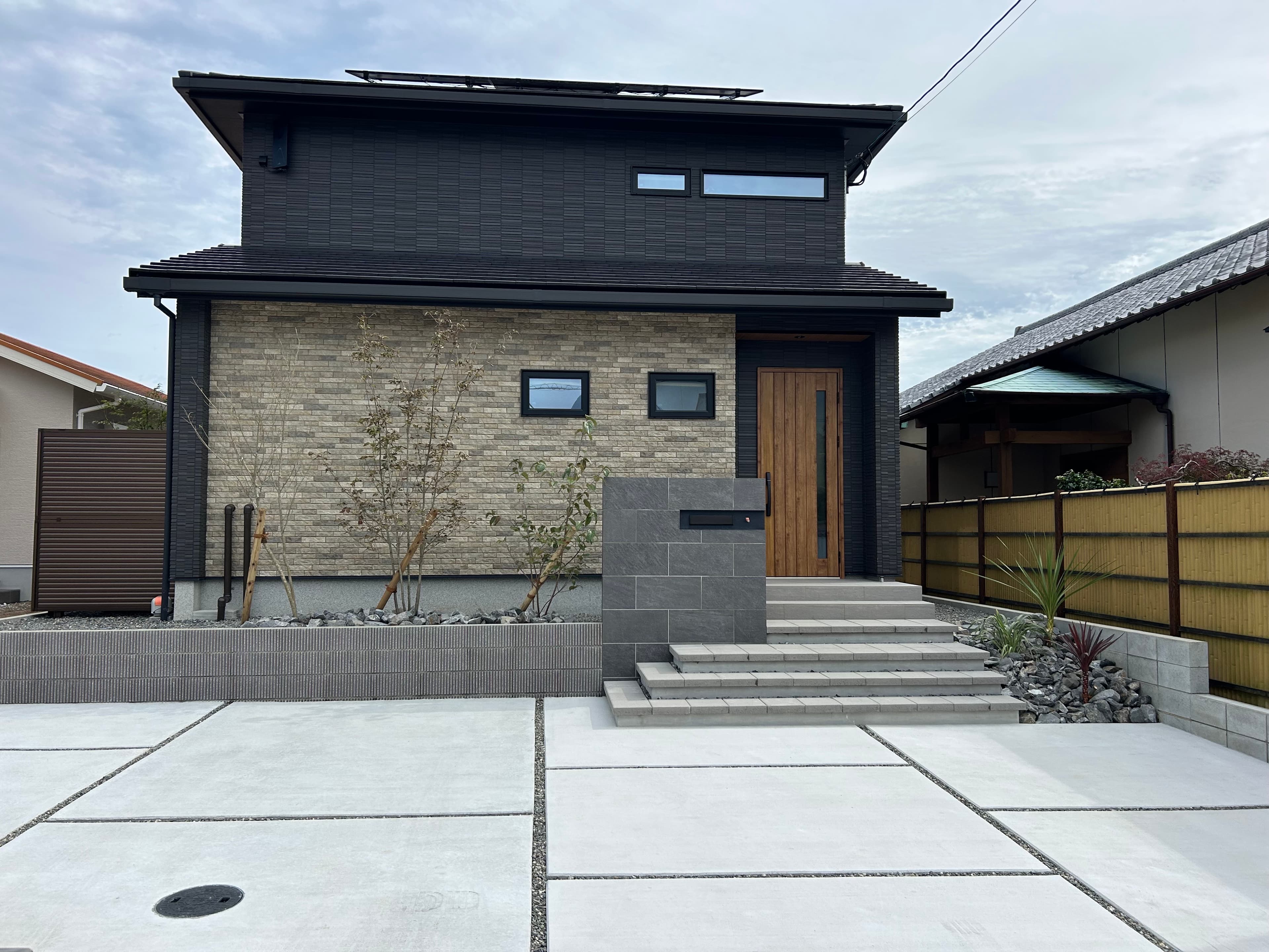 黒スレート住宅と整然のアプローチ